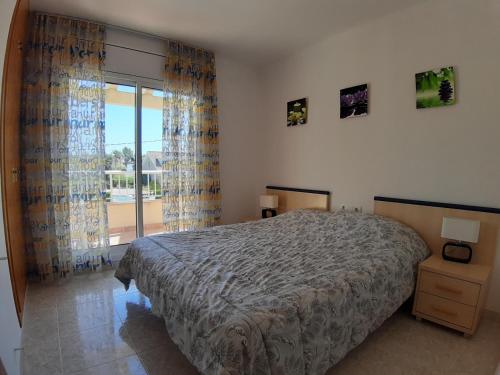 ein Schlafzimmer mit einem Bett und einem großen Fenster in der Unterkunft Villa Naomi in Les tres Cales