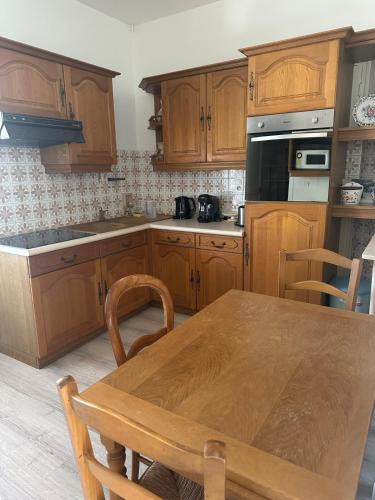 une cuisine avec des armoires en bois et une table en bois dans l'établissement Lumineux 2 pièces haut de villa, à Antibes
