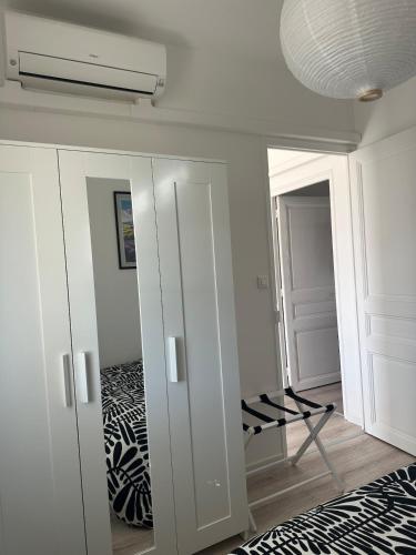 Cette chambre comprend une armoire blanche et une télévision. dans l'établissement Lumineux 2 pièces haut de villa, à Antibes