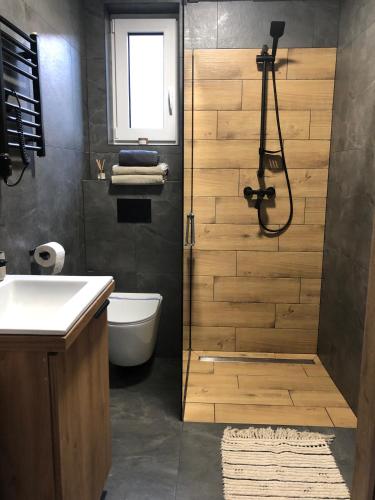 a bathroom with a shower with a toilet and a sink at Natura Home in Skoki