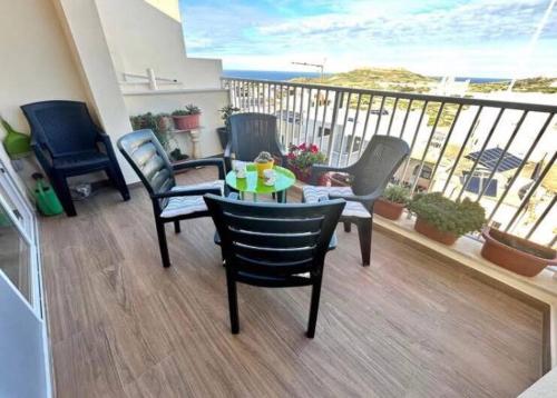 a balcony with chairs and a table with a view of the ocean at Gharb executive penthouse in Għarb