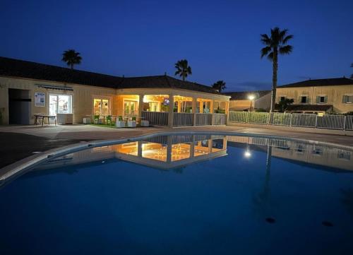 - une grande piscine en face d'une maison la nuit dans l'établissement Maison avec piscine dans résidence, à Béziers