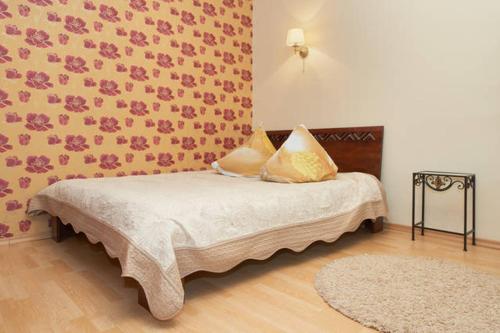1 dormitorio con 1 cama con pared de flores en Old Town Apartments, en Vilna