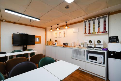 a room with a kitchen with tables and chairs at Hotel Laglas Asan in Asan