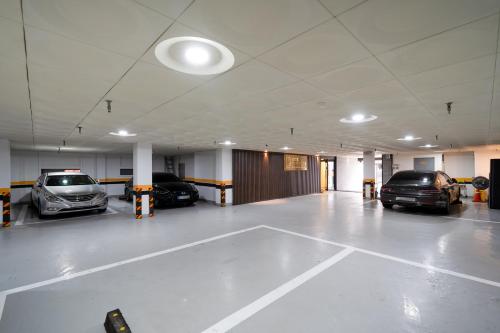 a parking lot with several cars parked in it at Hotel Laglas Asan in Asan