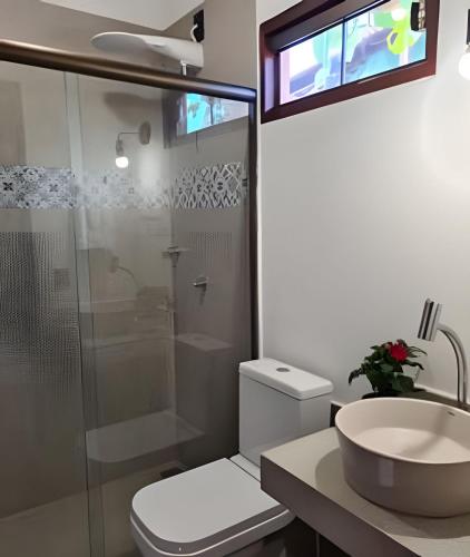 a bathroom with a toilet and a sink and a shower at Chalé À800Mts do Parq Chapada dos Veadeiros, Wi-fi in Alto Paraíso de Goiás