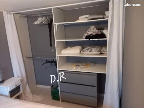 - un dressing avec des étagères blanches et des serviettes dans l'établissement Mobile Home de Charme 4 Personnes Sans Wifi, à Lançon-Provence