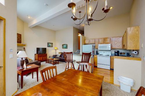 a kitchen and living room with a table and chairs at Wildernest Gore Trail Condo in Silverthorne