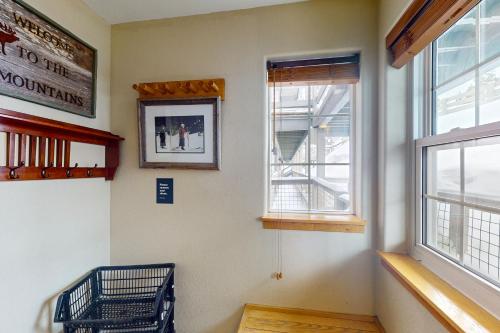 a room with two windows and a picture on the wall at Wildernest Gore Trail Condo in Silverthorne