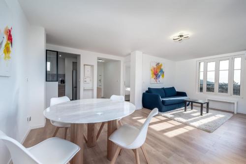 un salon blanc avec une table et des chaises blanches dans l'établissement 3 pièces cocon dans les hauteurs de Cannes vue mer, au Cannet