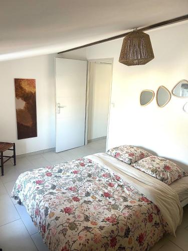 une chambre avec un lit avec un couvre-lit fleuri dans l'établissement Terracotta Nougat, à Montélimar