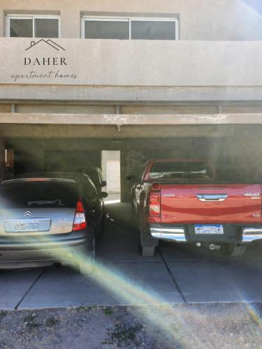 two cars are parked under a parking garage at Daher Apartment Homes in La Consulta