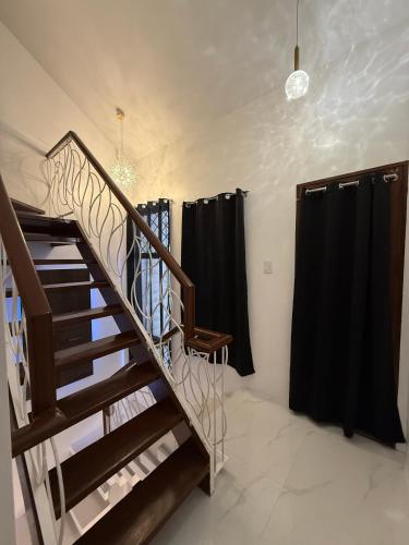 a staircase in a room with black curtains at Kandi Suites 2BR with private Jacuzzi 500 Mbps internet in Angeles