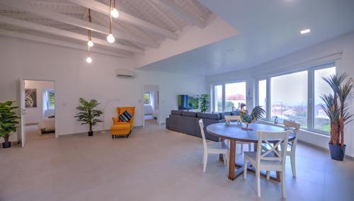 a living room with a table and chairs and a couch at Flores Whale Watch House in Faja Grande