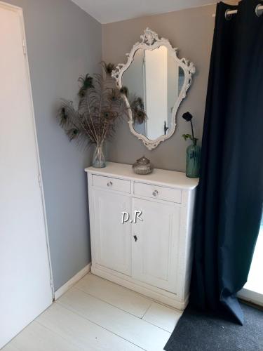 - un miroir au-dessus d'une commode blanche dans la chambre dans l'établissement Mobile Home de Charme 4 Personnes Sans Wifi, à Lançon-Provence