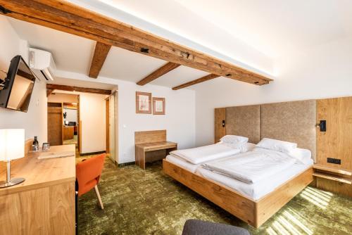 a bedroom with a bed and a desk at Gastagwirt in Eugendorf