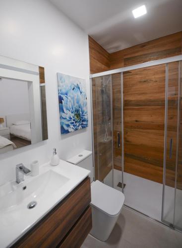 a bathroom with a toilet and a sink and a shower at Flores Whale Watch House in Faja Grande