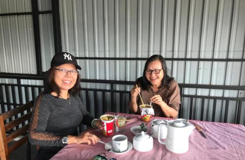 two women sitting at a table eating food at Ryan Residence & Restaurant in Negombo