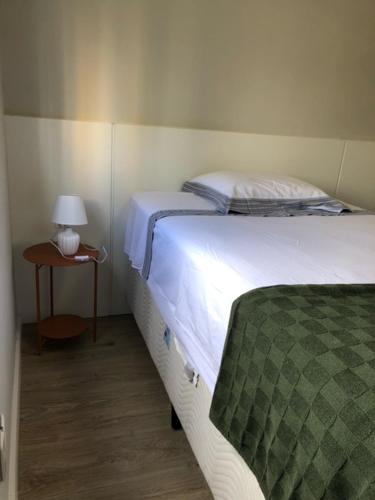 a bedroom with a bed and a table with a lamp at Rua Dr Diogo de Faria 671 - apto 132 in São Paulo