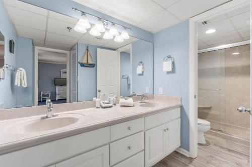 a bathroom with a sink and a toilet and a mirror at Watercrest 1509 - Sleeps 8 Amazing sunsets in Panama City Beach