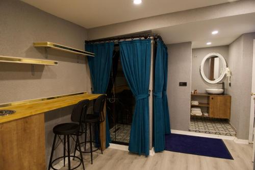 a bathroom with a blue shower curtain and two stools at Hotel Mara İstanbul in Istanbul