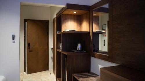 Durrat AlJawharah Hotel Makkah في مكة المكرمة: حمام به دواليب خشبية ومرآة