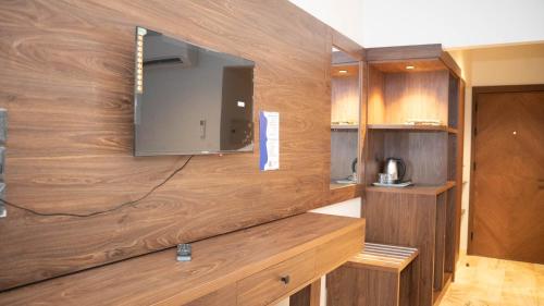 Durrat AlJawharah Hotel Makkah في مكة المكرمة: غرفة مع تلفزيون على جدار خشبي