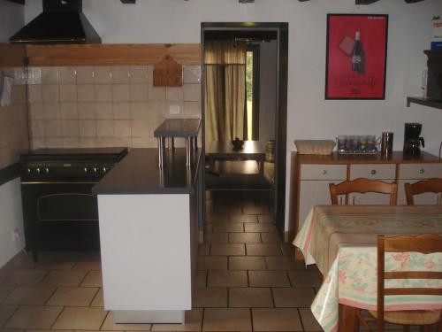 une cuisine avec un comptoir, une table et un sidx de table dans l'établissement Maison à la campagne, à Paslières