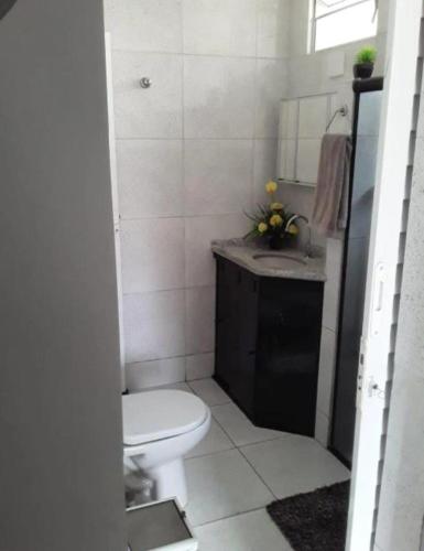 a bathroom with a white toilet and a sink at Casa ampla Olinda in Olinda
