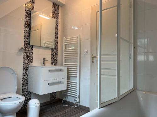 une salle de bain avec toilettes et douche en verre dans l'établissement Charmante maison de centre ville 8pers, à Perros-Guirec
