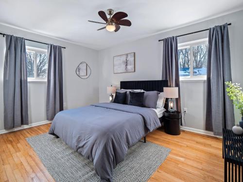 a bedroom with a bed and a ceiling fan at Two Entire Homes with Hot Tubs and Games Sleeps 20 in Akron