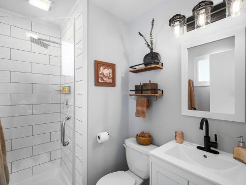 a white bathroom with a toilet and a sink at Two Entire Homes with Hot Tubs and Games Sleeps 20 in Akron