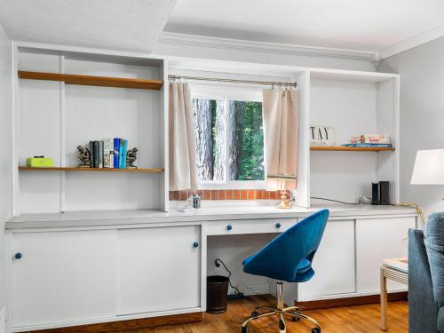 a kitchen with white cabinets and a blue chair at Two Entire Homes with Hot Tubs and Games Sleeps 20 in Akron