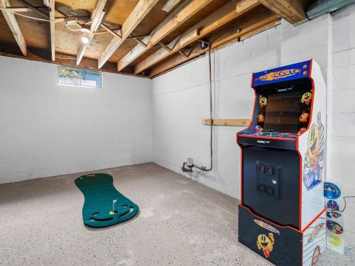 a room with a video game machine and a guitar at Two Entire Homes with Hot Tubs and Games Sleeps 20 in Akron