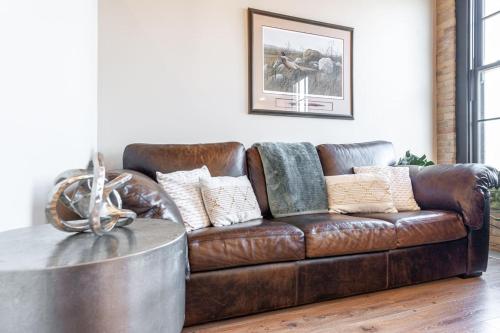 a brown leather couch in a living room with a table at MR Loft formerly The Lehman Studio Stratford in Stratford