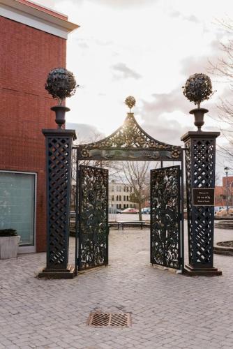 a gate with flowers on top of it in front of a building at MR Loft formerly The Lehman Studio Stratford in Stratford