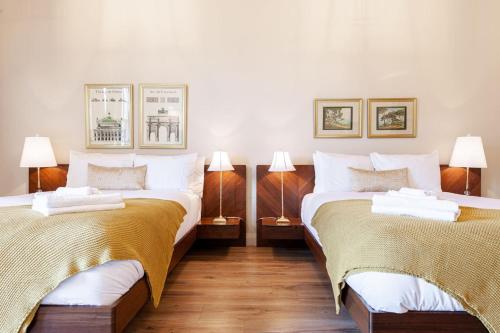 two beds in a room with two lamps at The Wallace Suite - Stratford in Stratford