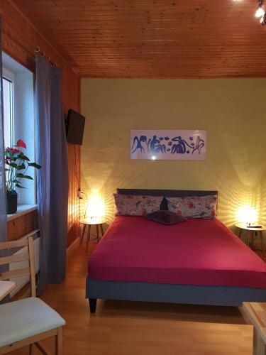 a bedroom with a bed with a red bedspread at Ferienhaus Gickelsberg in Hohnstein