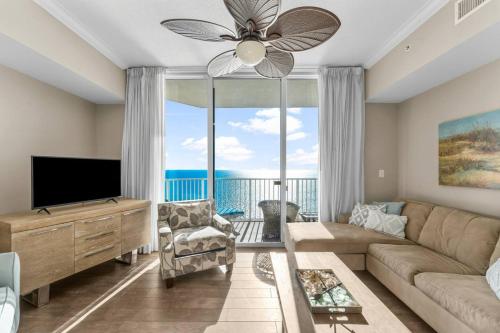 a living room with a couch and a large window at Family-Friendly Gulf-Front Condo w/Beach Access in Panama City Beach