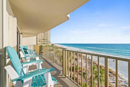 a balcony with blue chairs and the beach at Commodore 410 in Panama City Beach