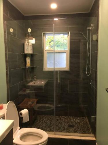 a bathroom with a shower with a toilet and a sink at Comfy 3-Bedroom Home with Modern Upgrades in London
