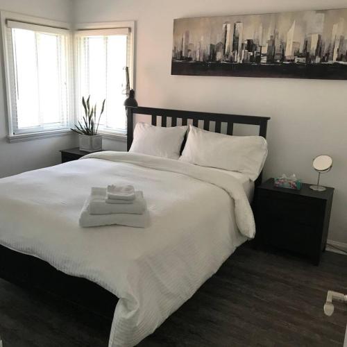 a bedroom with a large bed with two towels on it at Comfy 3-Bedroom Home with Modern Upgrades in London