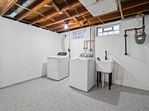 a kitchen with two washing machines and a sink at Luxurious Retreat with Sauna and Modern Design in Warrensville Heights