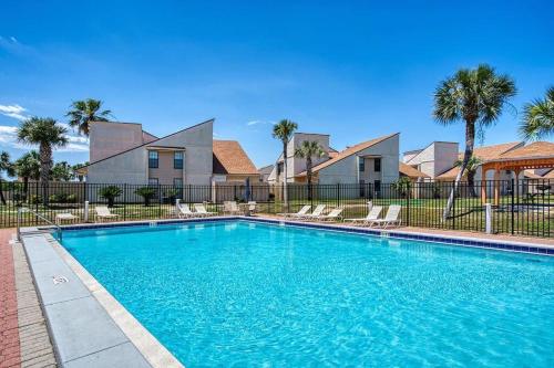 - une piscine avec des chaises en face d'une maison dans l'établissement Horizon South 33D - Sunstead Retreat - Sleeps 6, à Panama City Beach