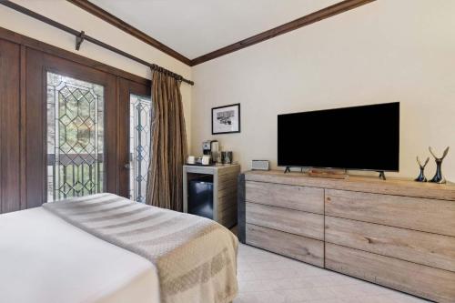 a bedroom with a television on a wooden dresser at The Charter at Beaver Creek C115 in Beaver Creek