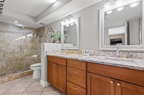 a bathroom with a sink and a toilet and a mirror at Gulf Peak Retreat - Watercrest 2 BR 2 BA - Sleeps in Panama City Beach