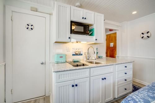 a kitchen with white cabinets and a sink at Ocean City Hideaway Walk to Boardwalk and Beach! in Ocean City