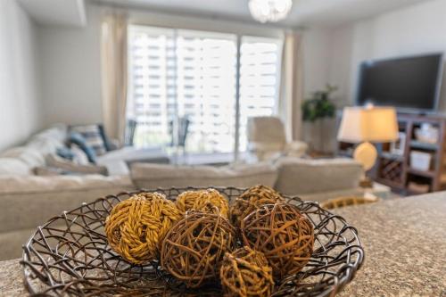 a living room with a table with baskets on it at Shores of Panama 727 - Same level parking space! in Panama City Beach