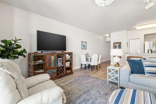 a living room with a couch and a tv at Shores of Panama 727 - Same level parking space! in Panama City Beach