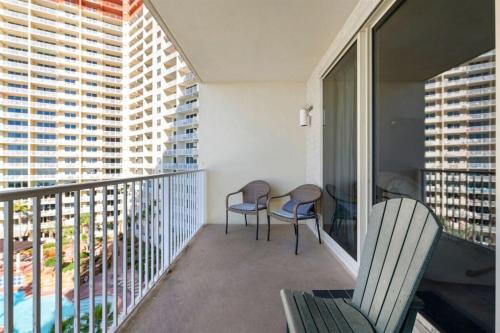 a balcony with two chairs and a table on it at Shores of Panama 727 - Same level parking space! in Panama City Beach